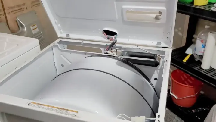 Open dryer cabinet showing drum belt and internal components — inspected for burning smell cause